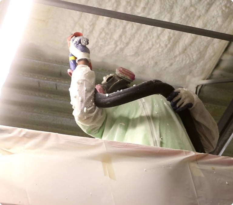 Koala installer applying insulation in an attic
